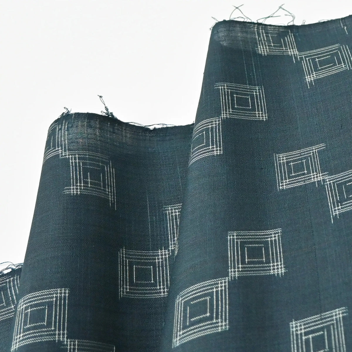 Detailed view of vintage fine silk kimono fabric piece in dark emerald green with simple square pattern.