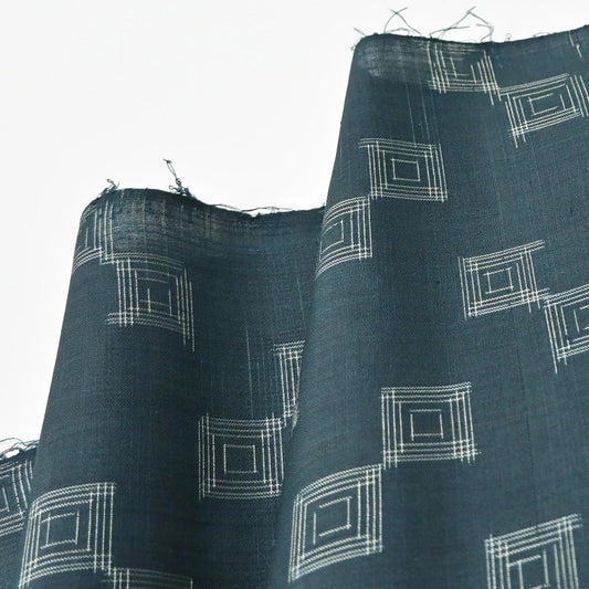 Detailed view of vintage fine silk kimono fabric piece in dark emerald green with simple square pattern.