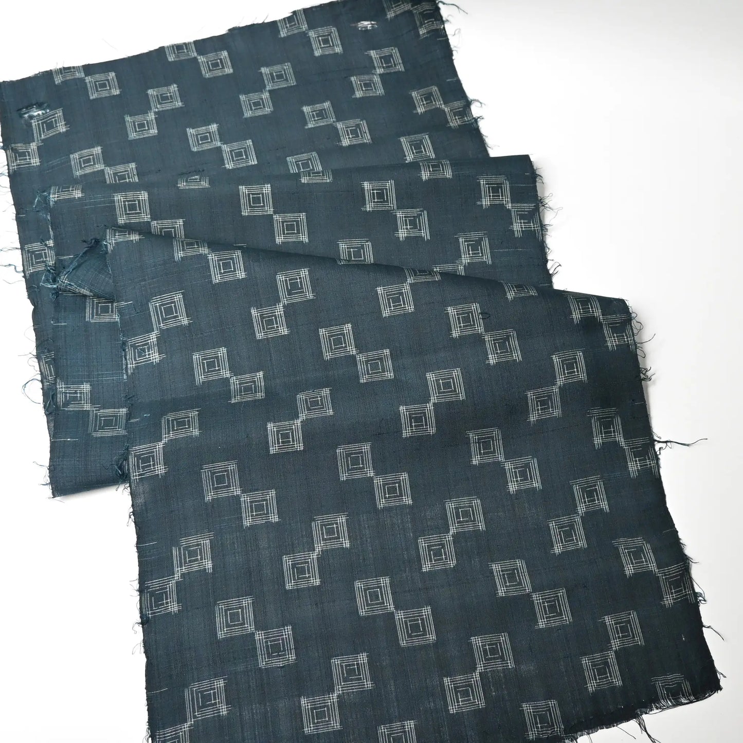 Full view of vintage fine silk kimono fabric piece in dark emerald green with simple square pattern.