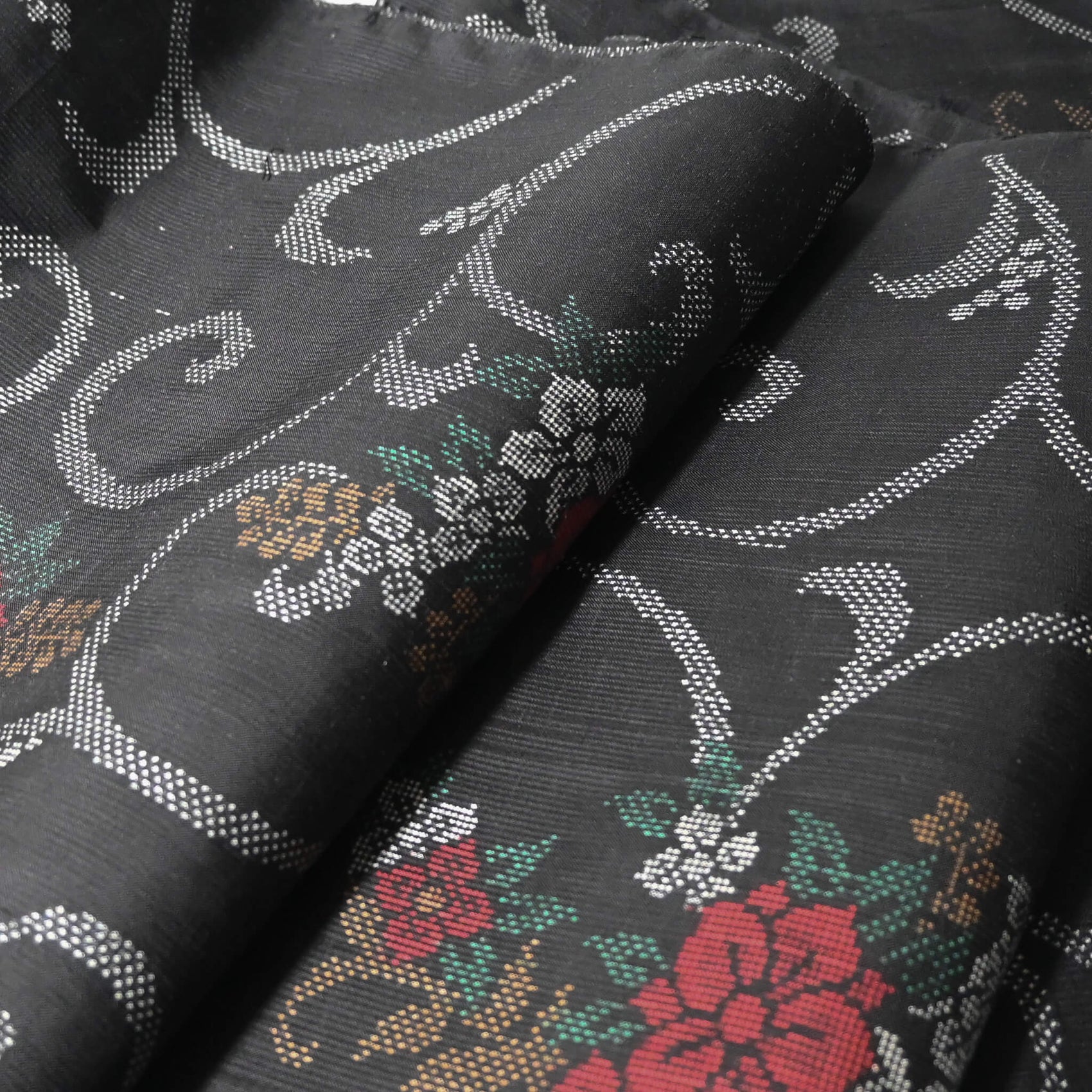 Close up view of vintage flora Oshima tsumugi silk kimono fabric sold by the metre.