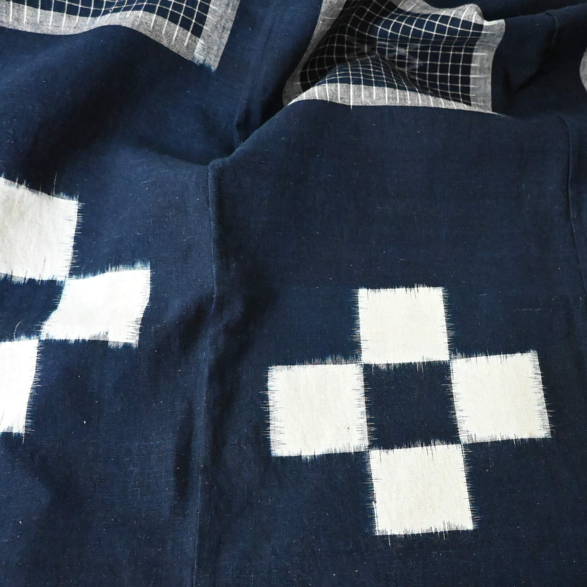 Close-up view of vintage Japanese four-panel indigo kasuri cotton futon cover with a bold geometric design.