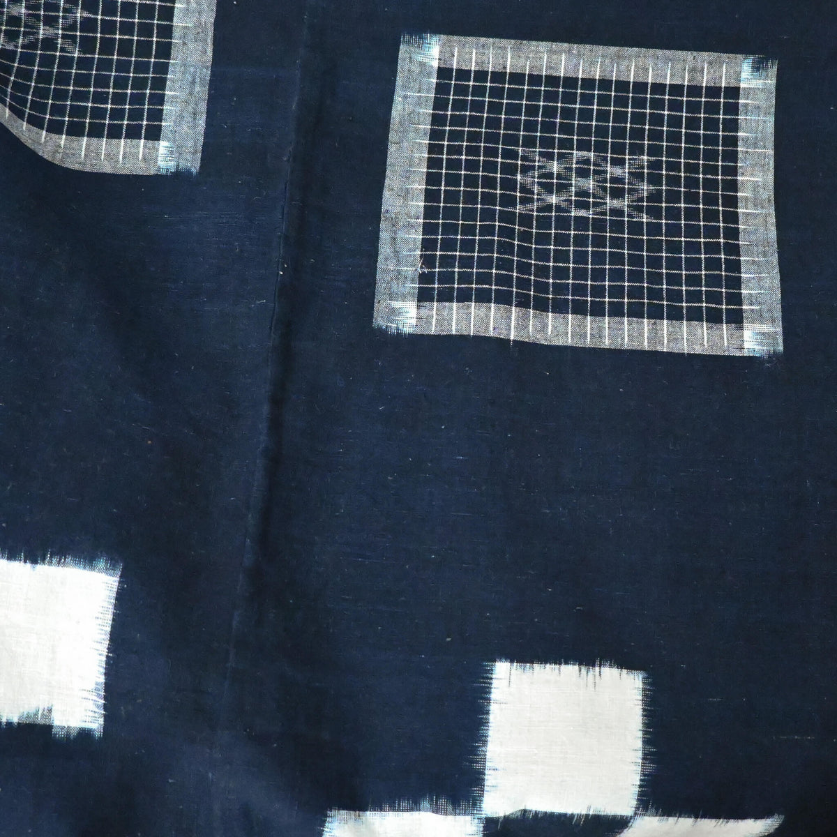 Close-up view of vintage Japanese four-panel indigo kasuri cotton futon cover with a bold geometric design.