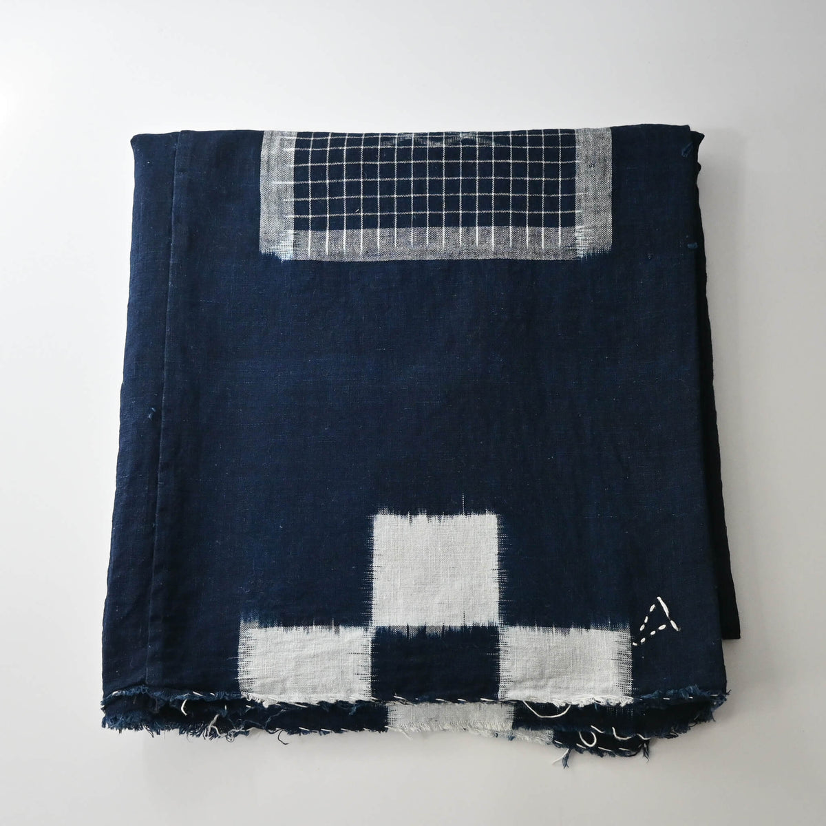 Vintage Japanese four-panel indigo kasuri cotton futon cover with a bold geometric design.