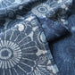 Close-up view of vintage four-panel indigo katazome dyed cotton futon cover with chrysanthemum arabesque motif.