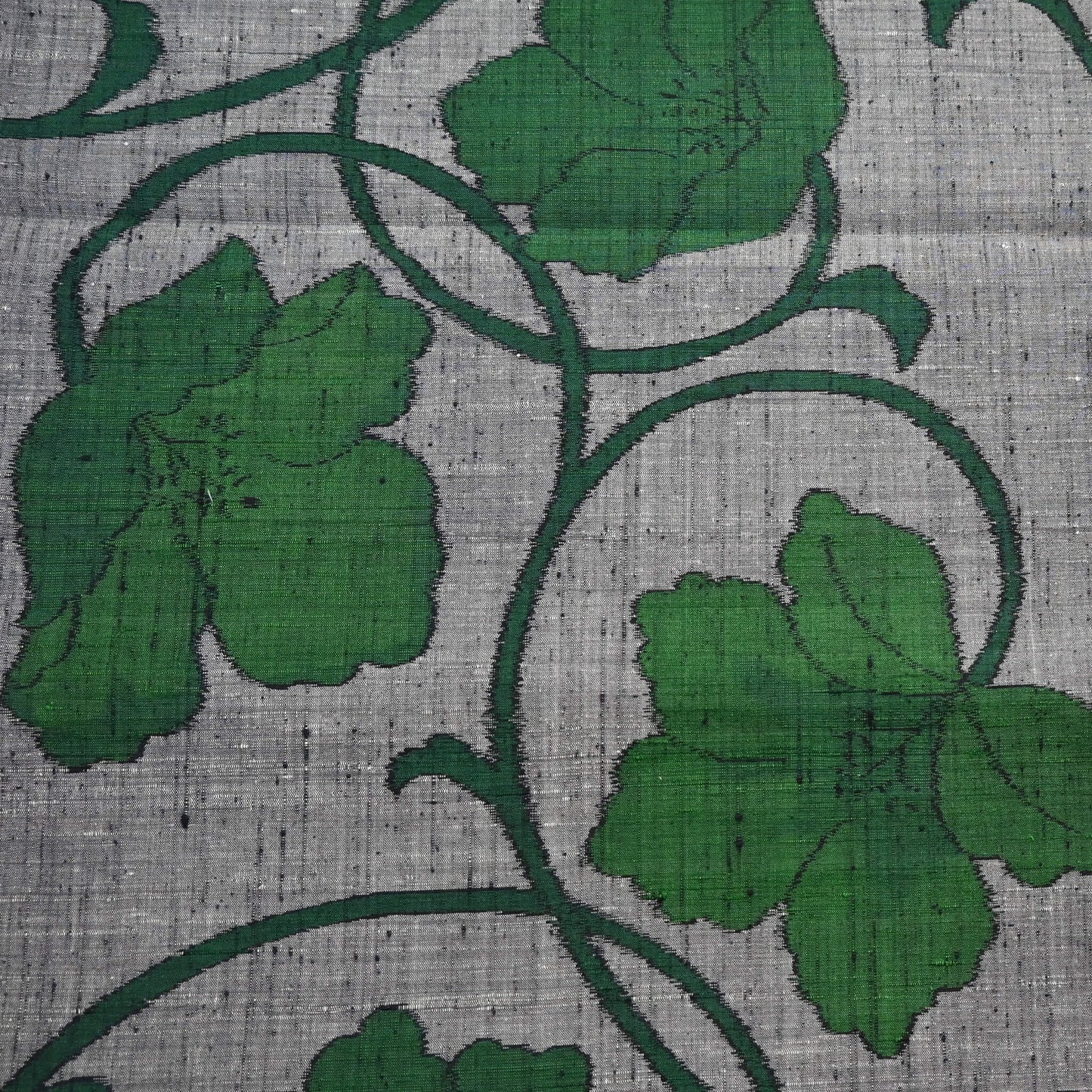 Close-up view of vintage Japanese grey tsumugi silk kimono fabric with deep green large-scale floral design.