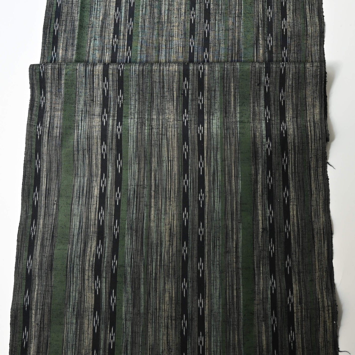 Full view of vintage tsumugi silk kimono fabric with olive green, charcoal and black stripes, and kasuri accents.