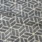 Close-up view of vintage grey tsumugi kimono silk with geometric pattern.