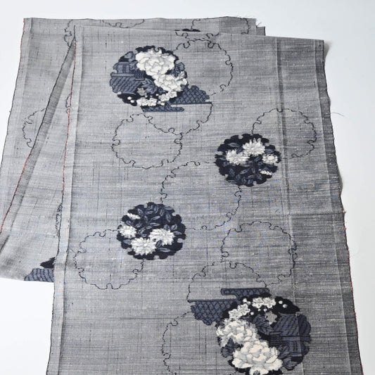 Vintage grey tsumugi silk kimono fabric piece with floral pattern.