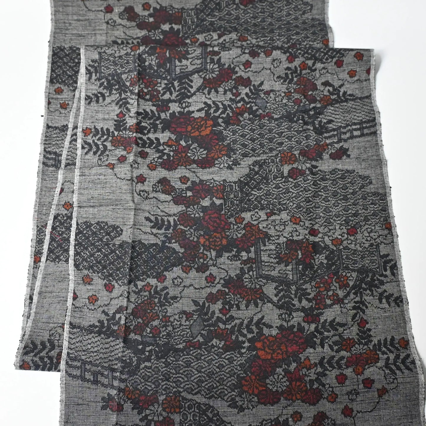 Full view of vintage grey tsumugi silk kimono fabric, garden with flower design.