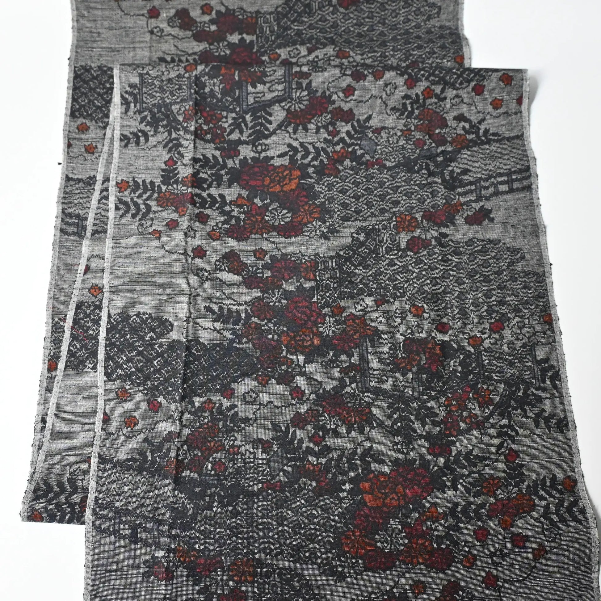 Full view of vintage grey tsumugi silk kimono fabric, garden with flower design.