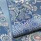Close-up view of vintage heavy silk crepe chirimen kimono fabric, katazome dyed chrysanthemum in soft blue.