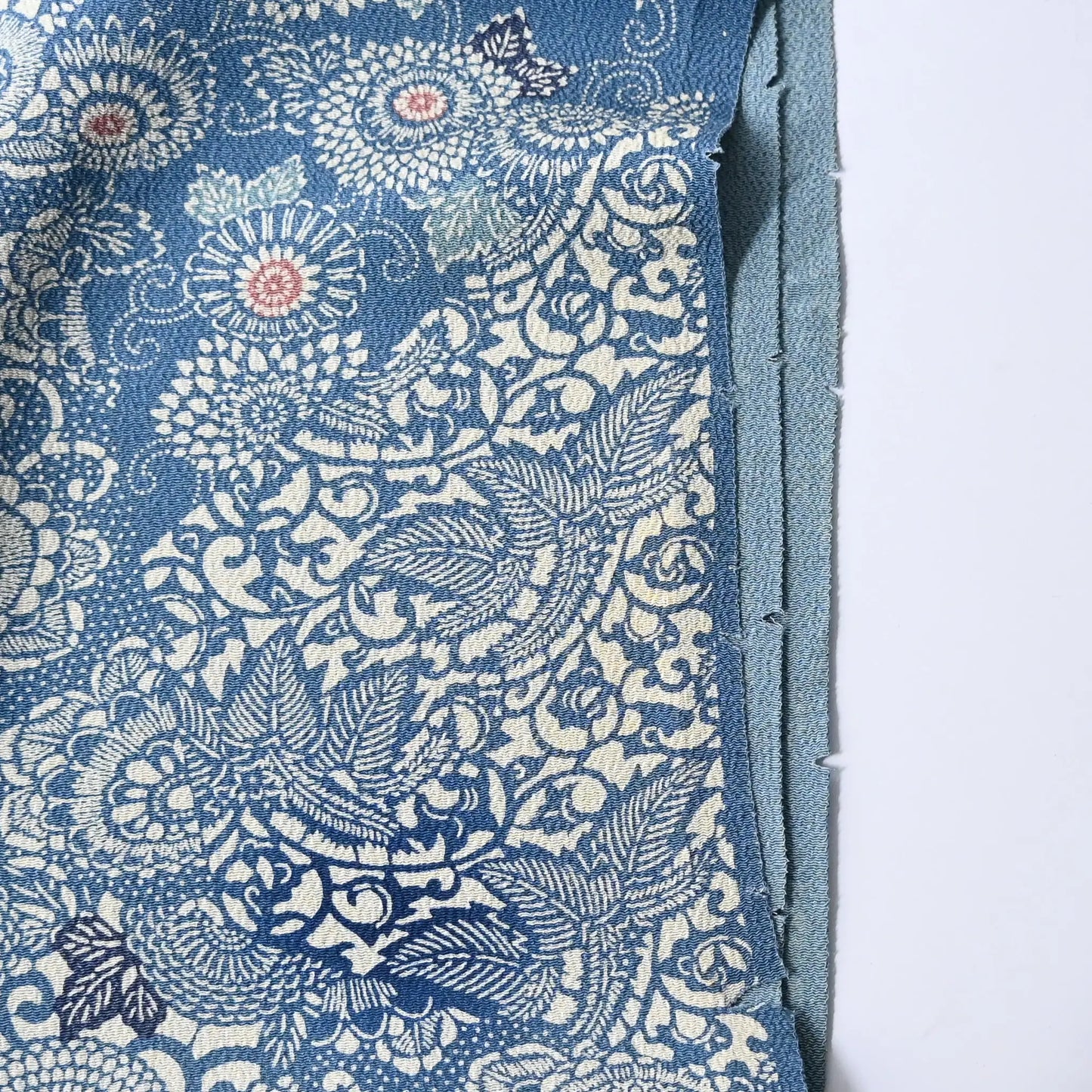 Vintage heavy silk crepe chirimen kimono fabric, katazome dyed chrysanthemum in soft blue has small cuts on selvedge.