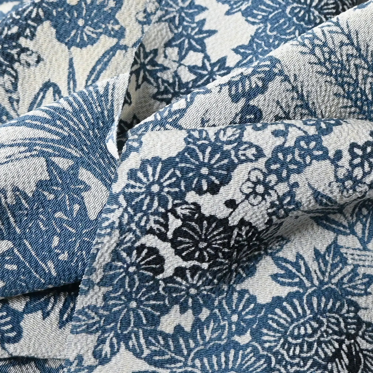 Detailed view of vintage heavy silk crepe Chirimen kimono fabric with indigo floral pattern.