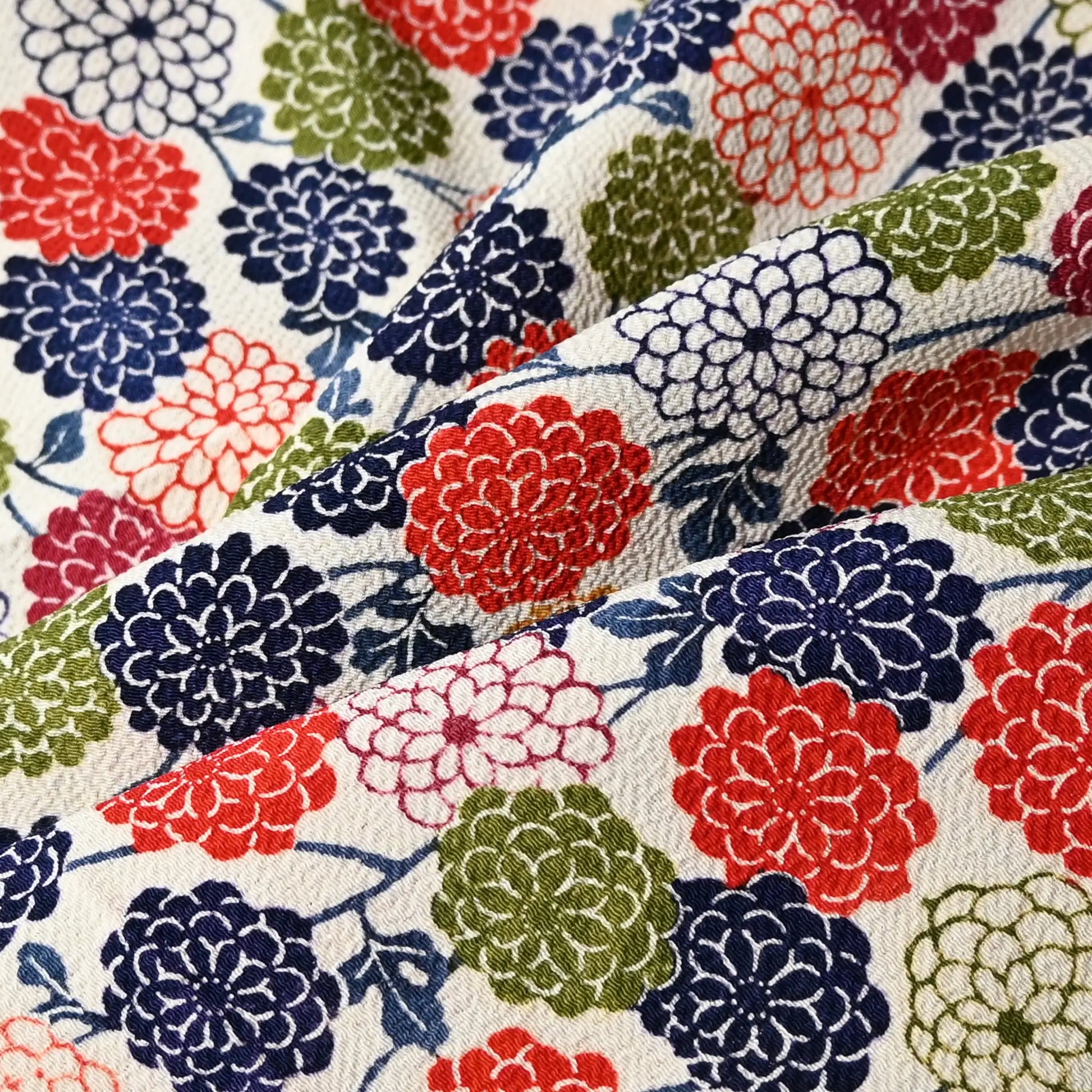 Close-up view of vintage heavy silk crepe, Chirimen, kimono fabric piece with multicolour chrysanthemum motif.