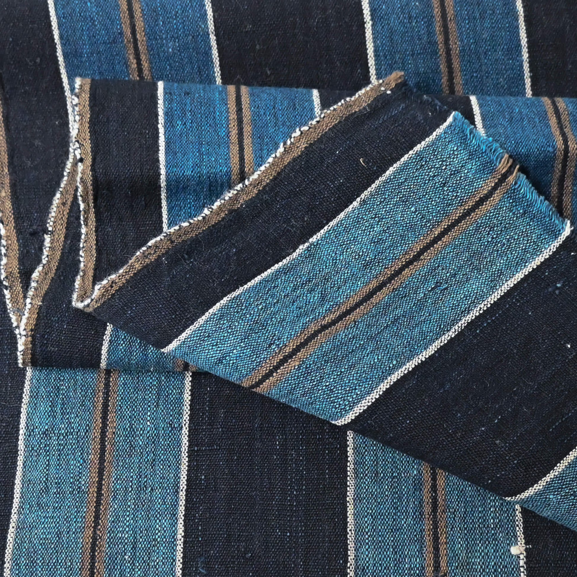Close-up view of vintage indigo bold stripe cotton fabric piece, medium to heavy weight.