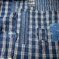 Detailed view of vintage Japanese indigo check cotton Boro futon cover with layers of mending.