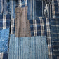 Detailed view of vintage Japanese indigo check cotton Boro futon cover with layers of mending.