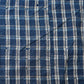 Detailed view of vintage Japanese indigo check cotton Boro futon cover with layers of mending.