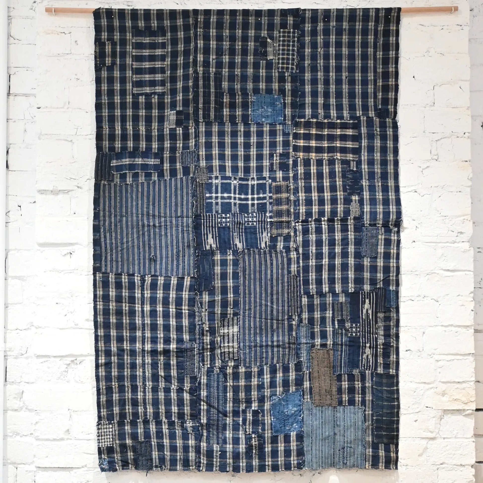 Full view of vintage Japanese indigo check cotton Boro futon cover with layers of mending.