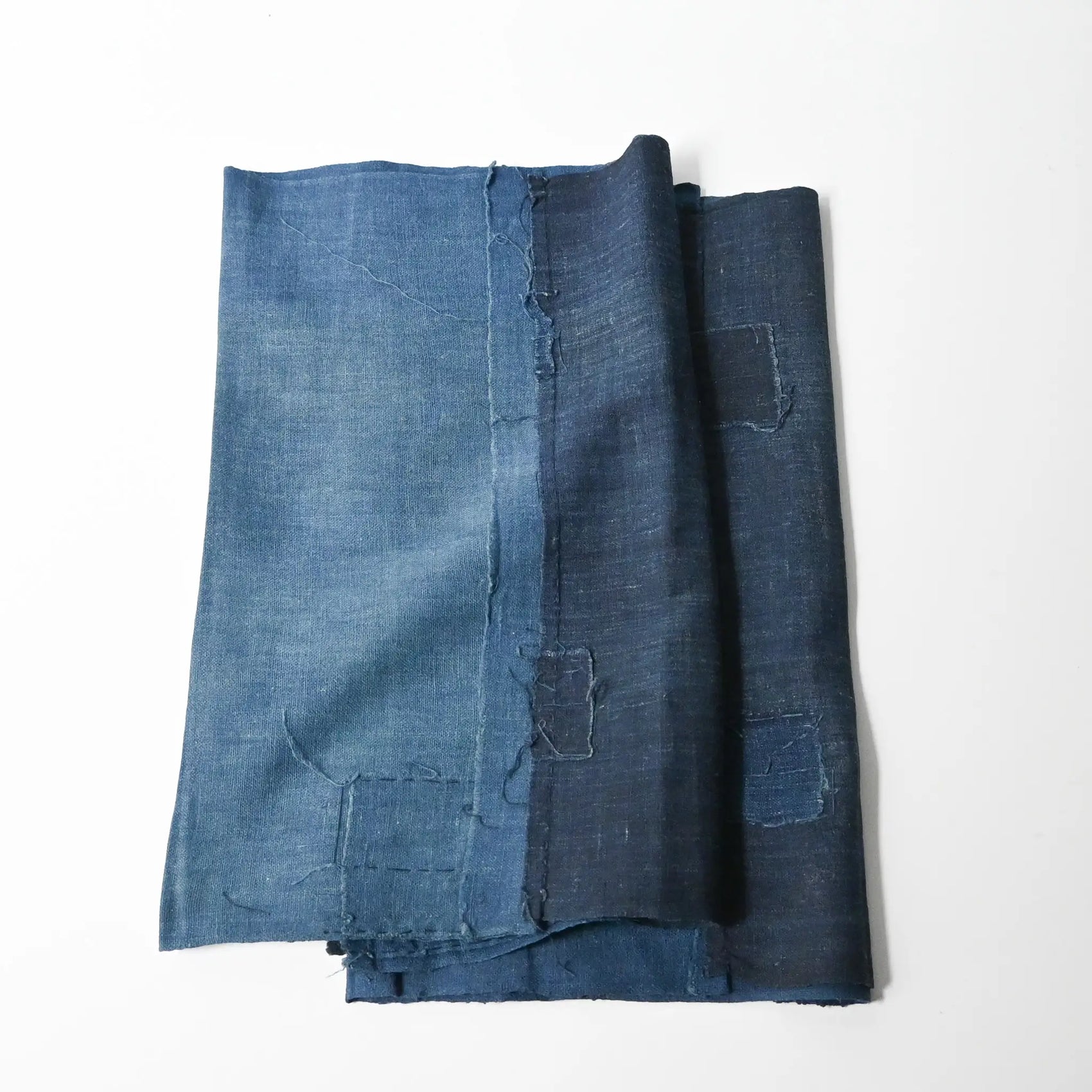 Two fragments of vintage indigo cotton kimono lining with charming hand-stitched mends.
