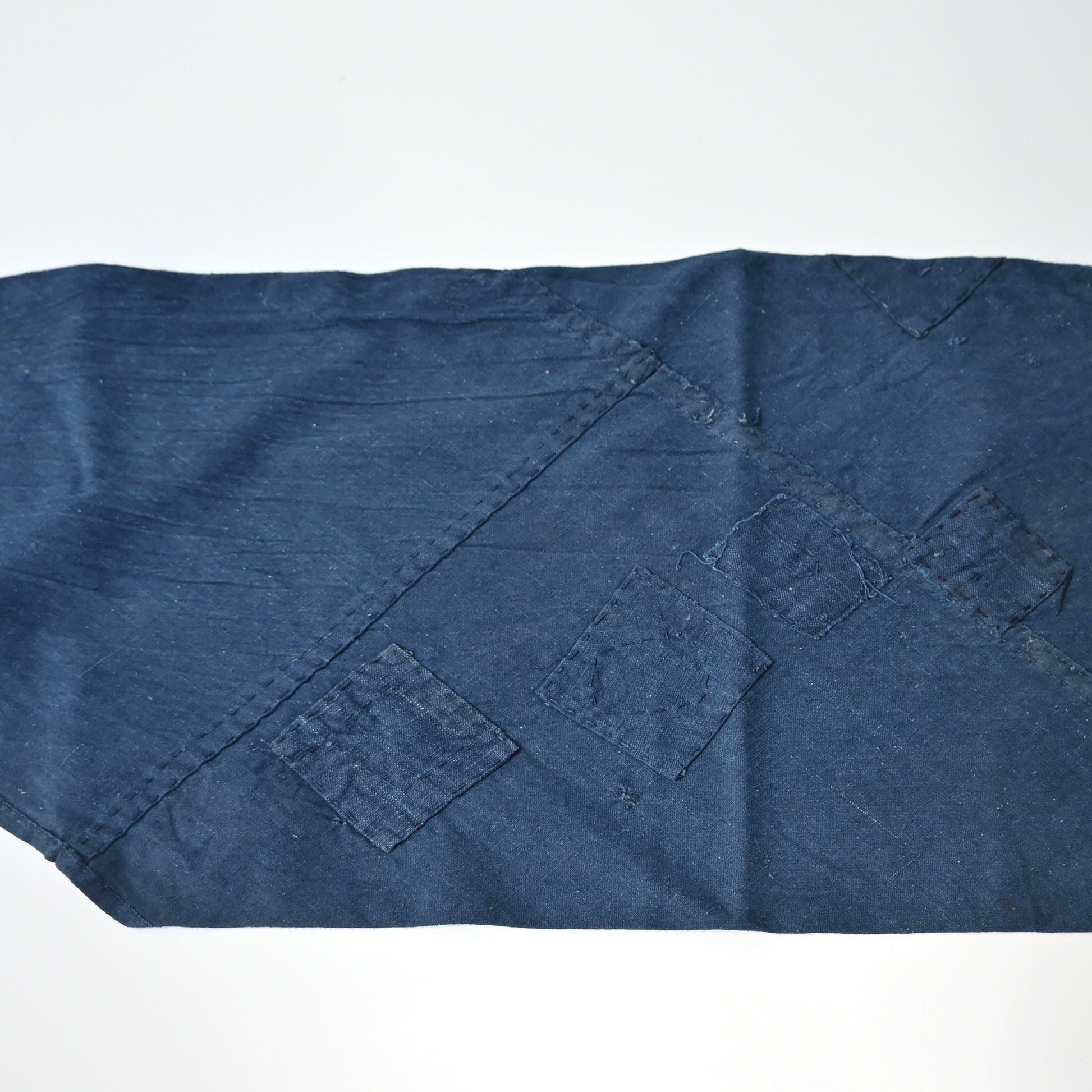 Detailed view of rare vintage indigo cotton tube cloth with mends.