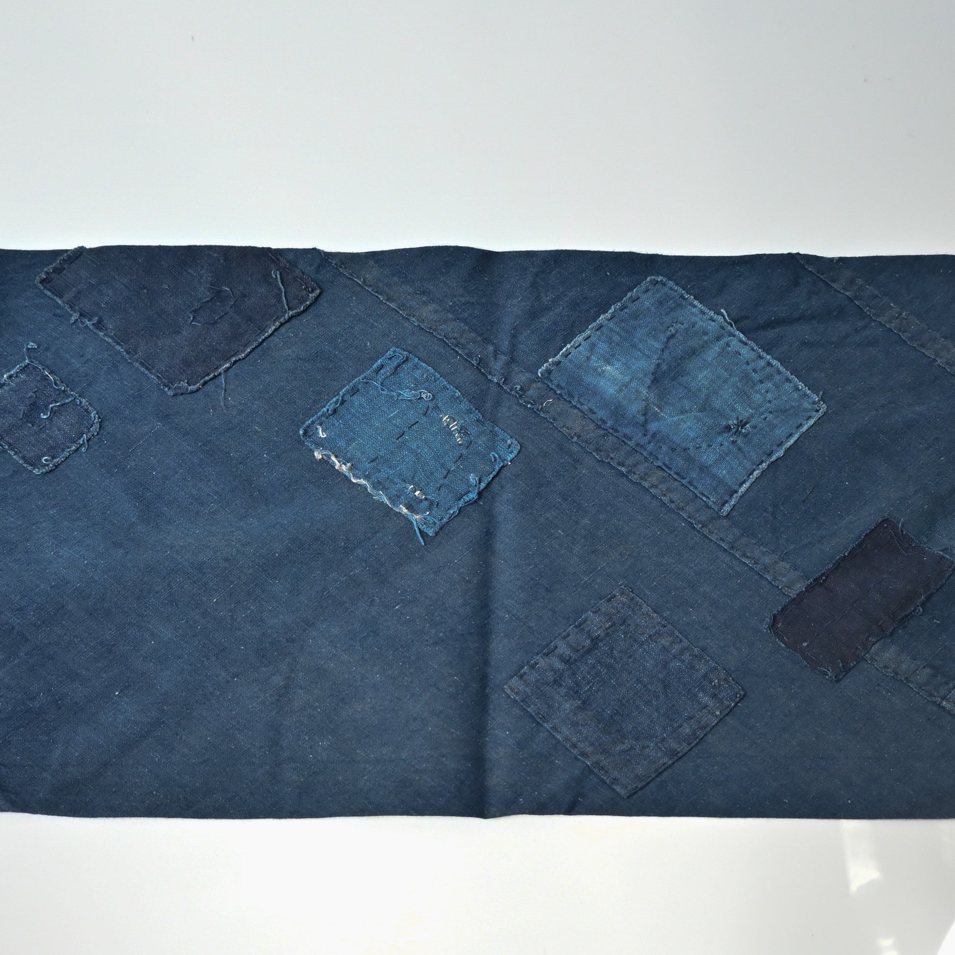 Detailed view of rare vintage indigo cotton tube cloth with mends.