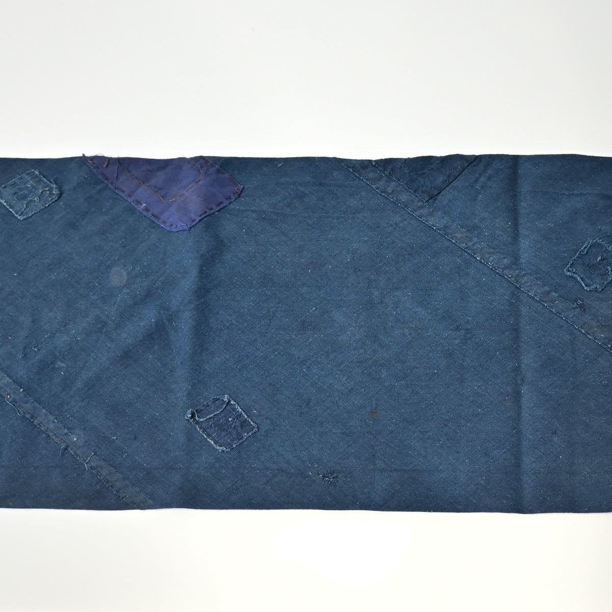 Detailed view of rare vintage indigo cotton tube cloth with mends.