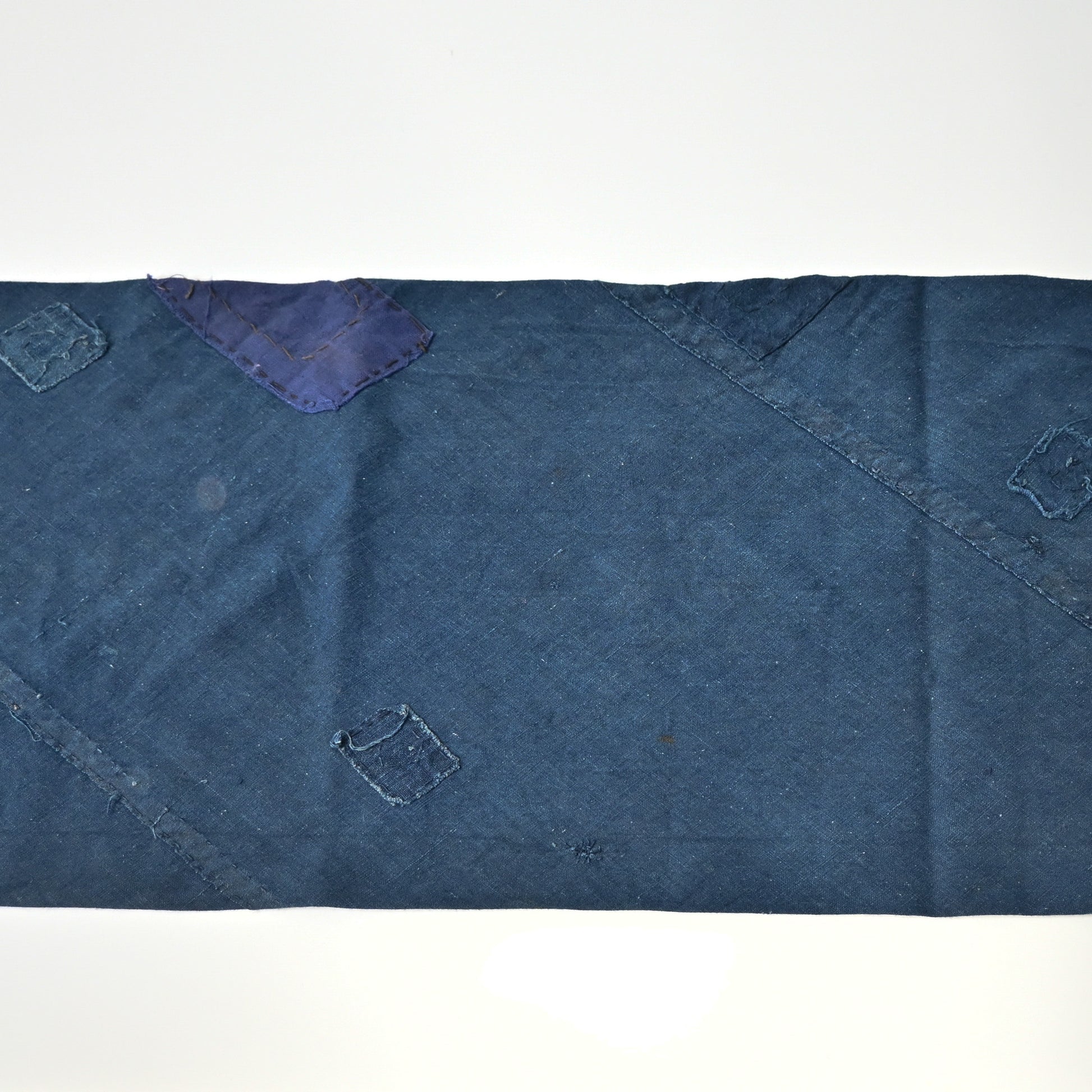 Detailed view of rare vintage indigo cotton tube cloth with mends.