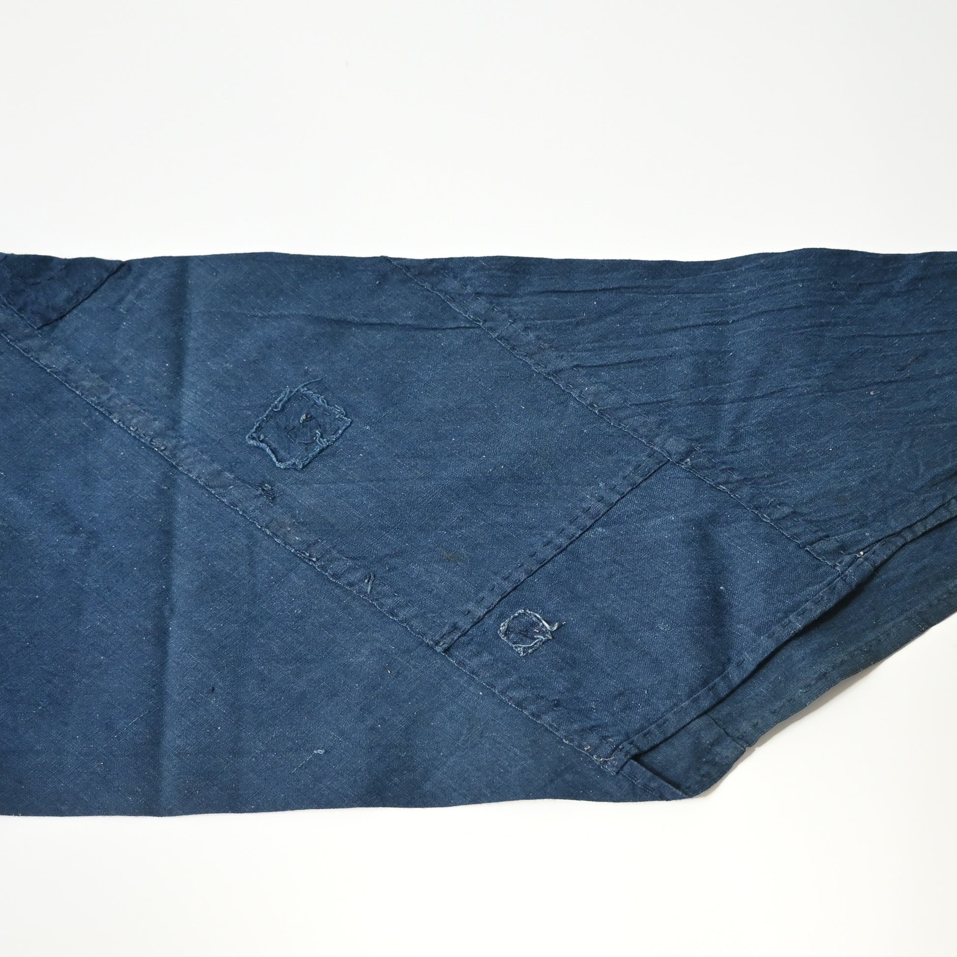 Detailed view of rare vintage indigo cotton tube cloth with mends.