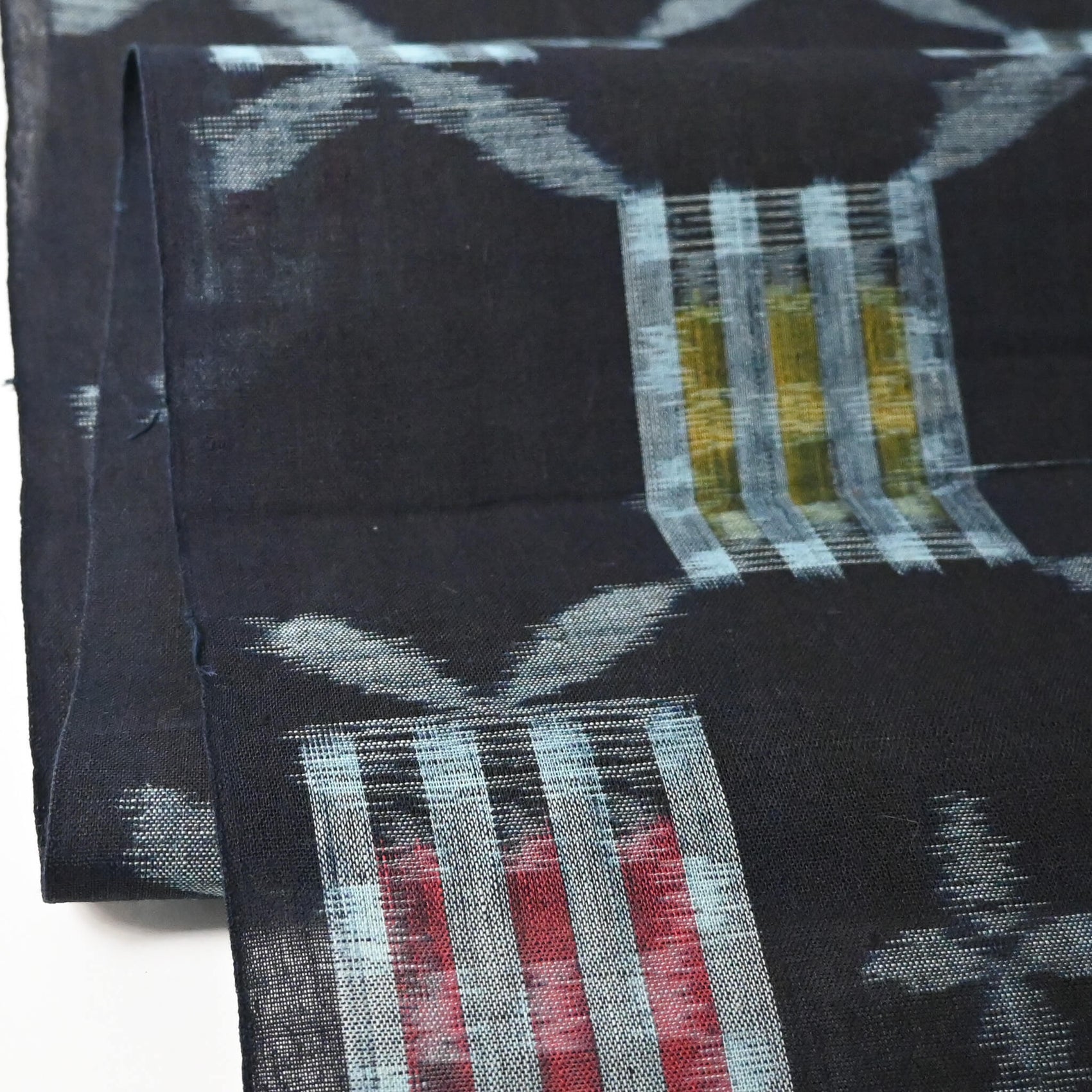Close-up view of vintage Japanese Bingo kasuri cotton kimono fabric roll sold by the metre.