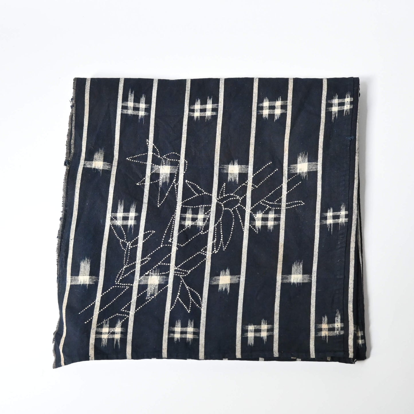 Vintage three-panel indigo kasuri cotton furoshiki with hand stitched botanical motifs on the corner.