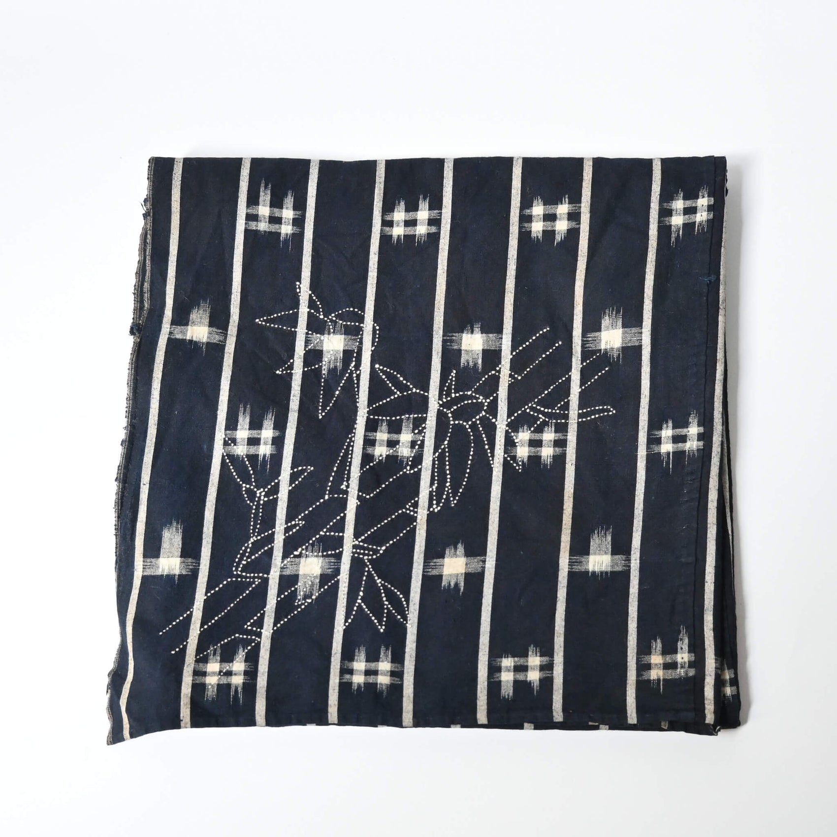 Vintage three-panel indigo kasuri cotton furoshiki with hand stitched botanical motifs on the corner.