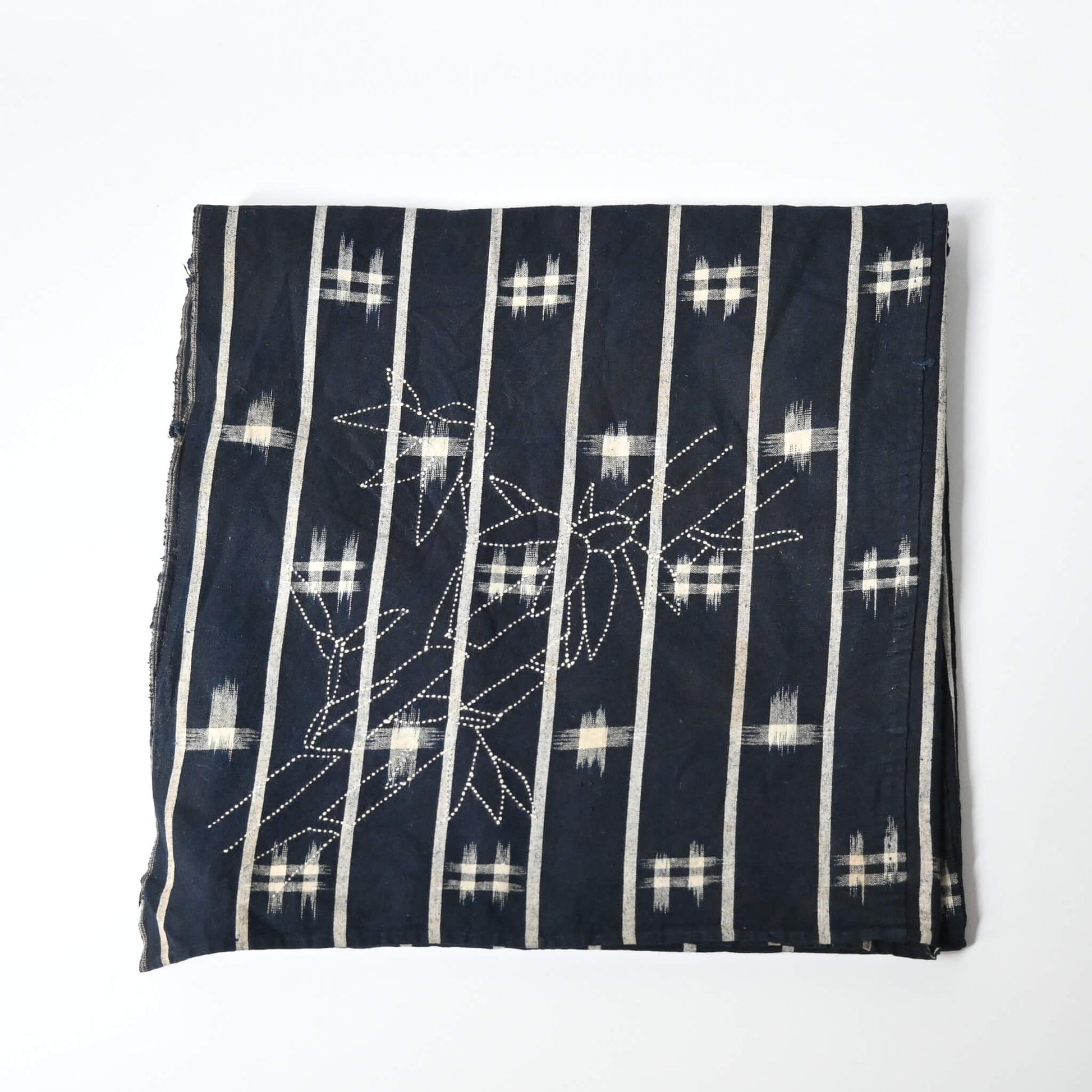 Vintage three-panel indigo kasuri cotton furoshiki with hand stitched botanical motifs on the corner.