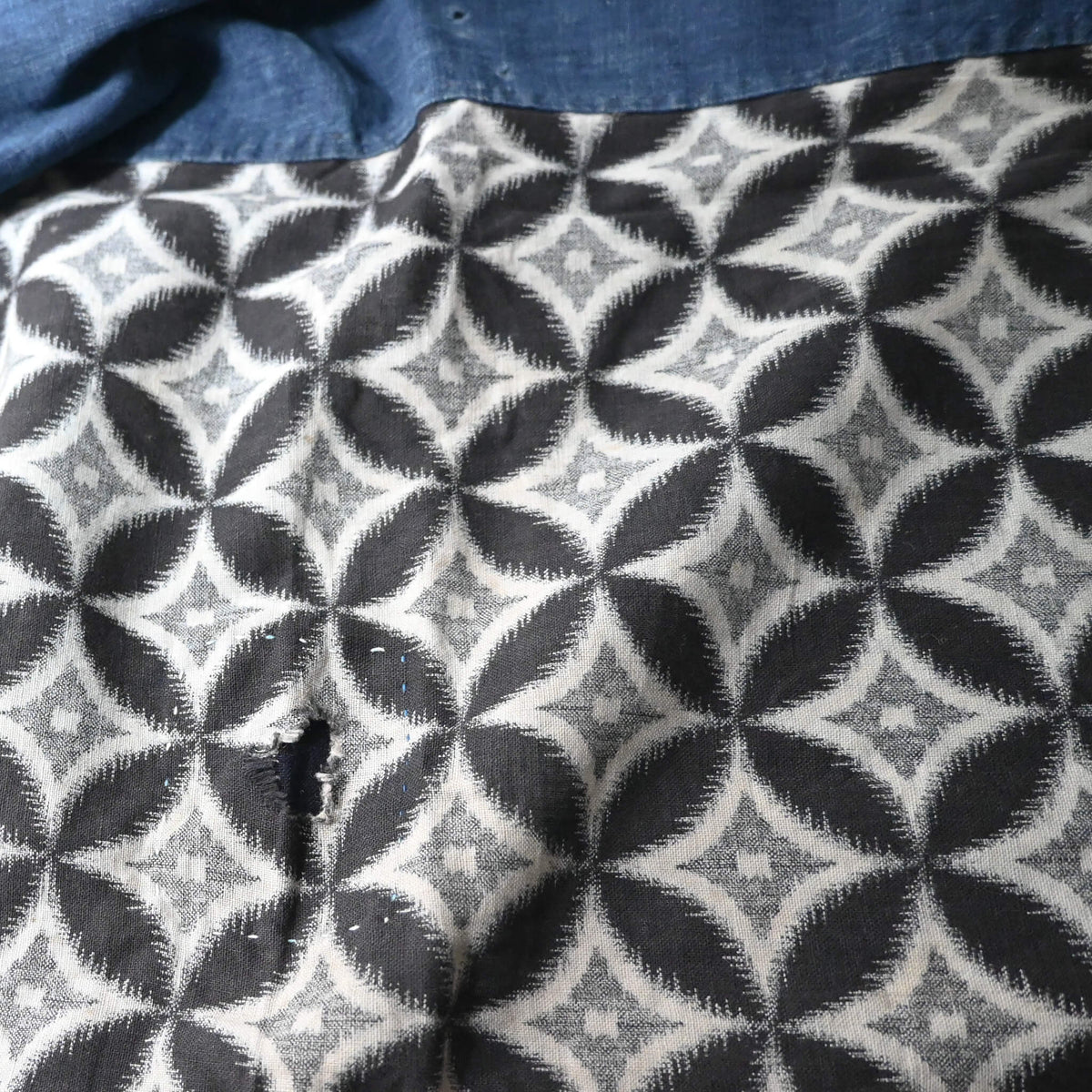 Detailed view of vintage Japanese indigo cotton Koshimaki, a traditional waist wrap, with Kasuri Shippō-tsunagi motif.