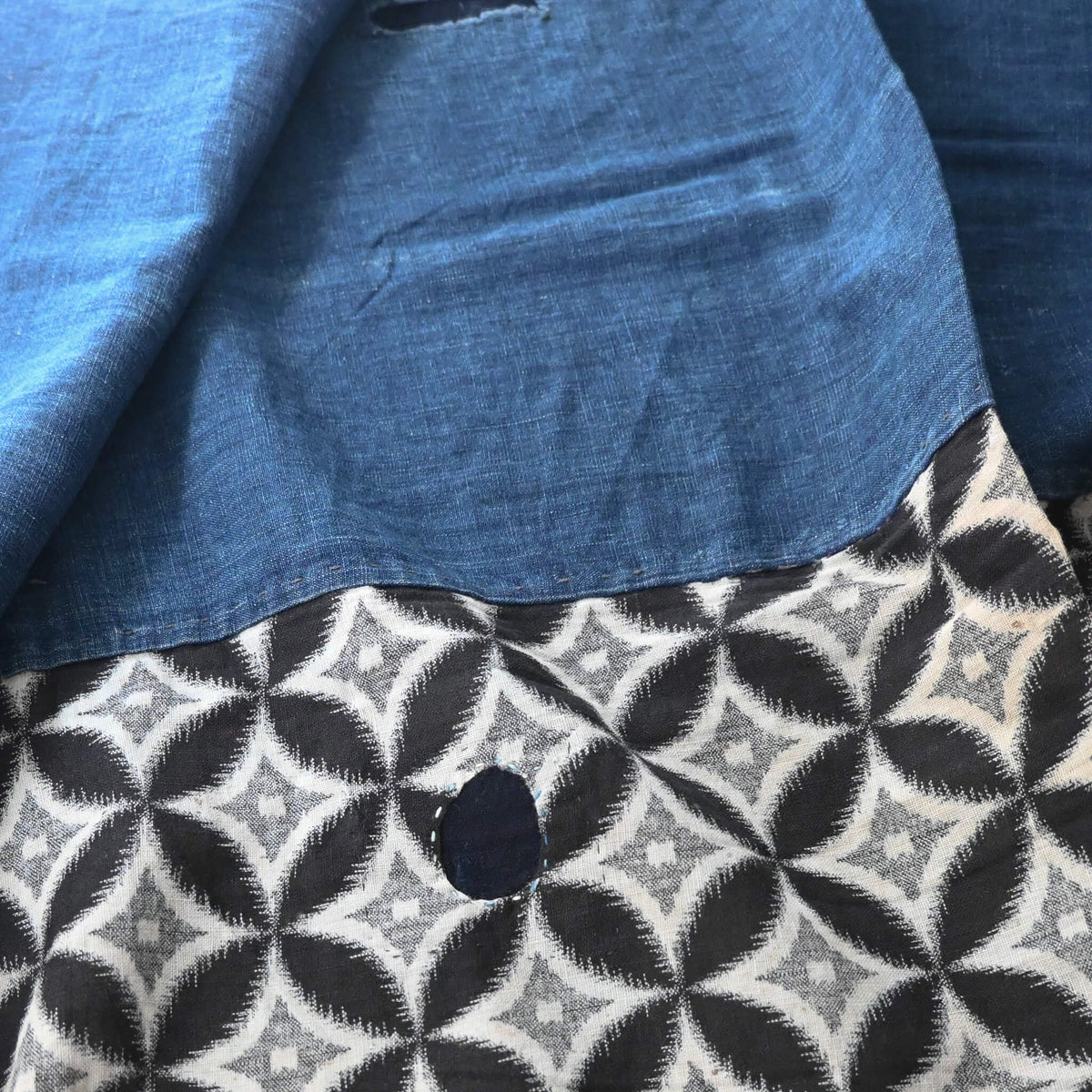 Detailed view of vintage Japanese indigo cotton Koshimaki, a traditional waist wrap, with Kasuri Shippō-tsunagi motif.