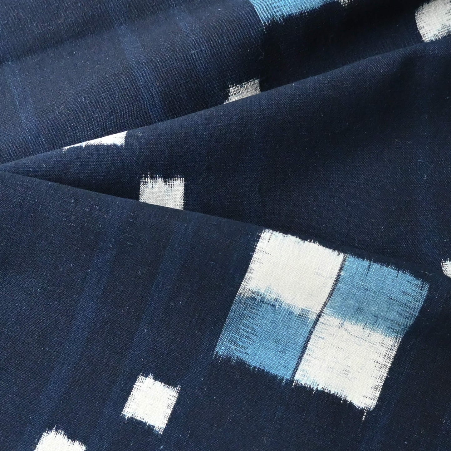 Close-up view of vintage Japanese indigo kasuri cotton panel from San'in region, a simple geometric pattern.