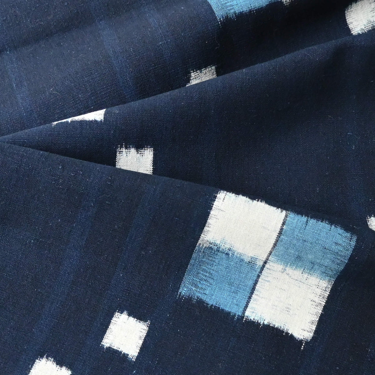 Close-up view of vintage Japanese indigo kasuri cotton panel from San'in region, a simple geometric pattern.