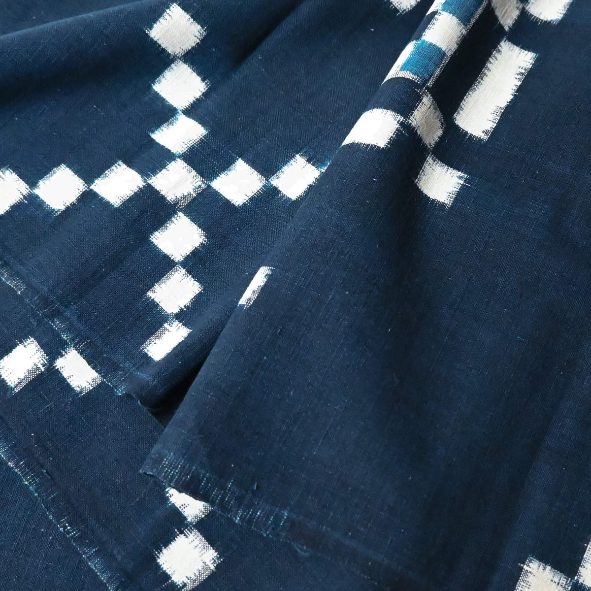 Close-up view of vintage Japanese indigo kasuri cotton panel from San'in region, a simple geometric pattern.