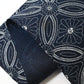 Close-up view of vintage indigo katazome cotton piece with Shippo-tsunagi with stylised chrysanthemum motif.