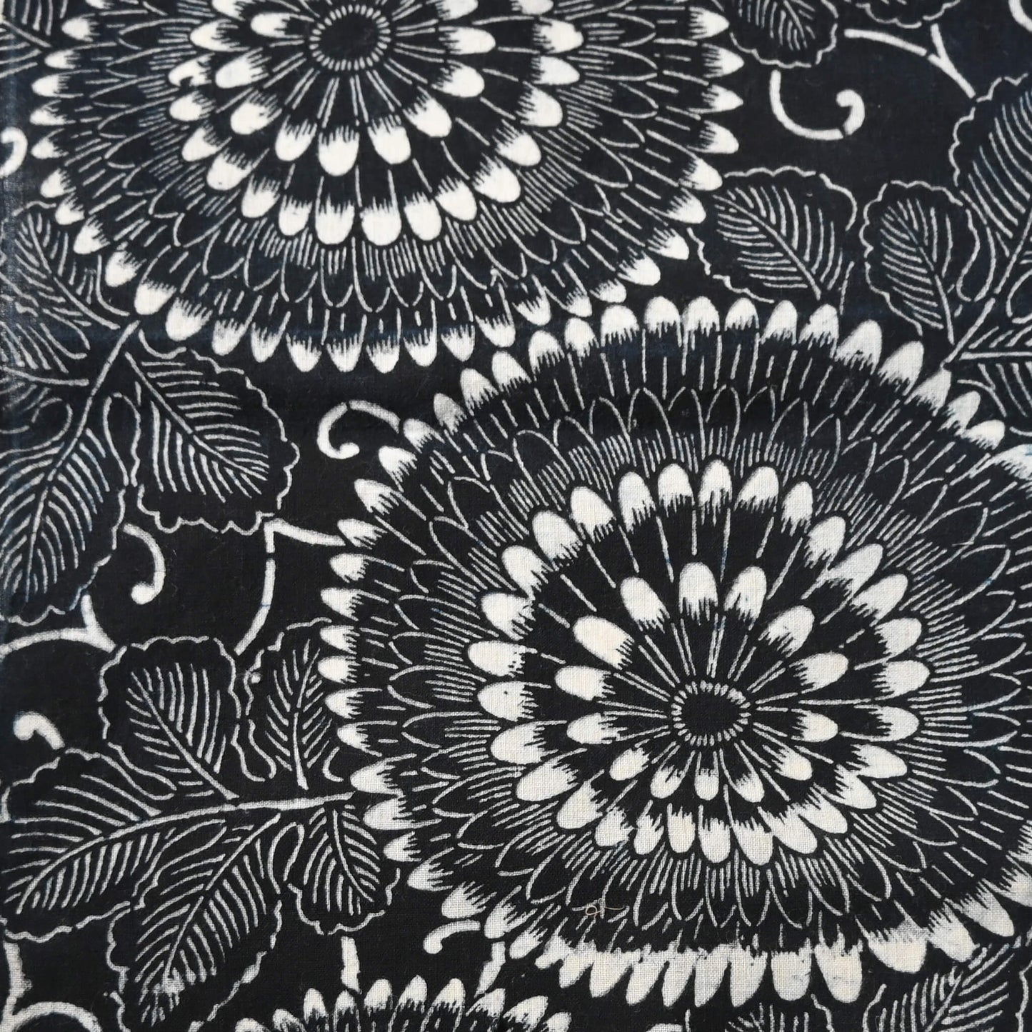Close-up view of vintage indigo katazome stencil dyed cotton piece with a bold chrysanthemum design.