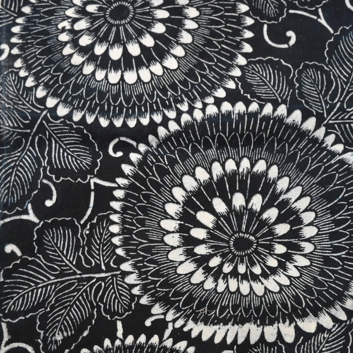 Close-up view of vintage indigo katazome stencil dyed cotton piece with a bold chrysanthemum design.