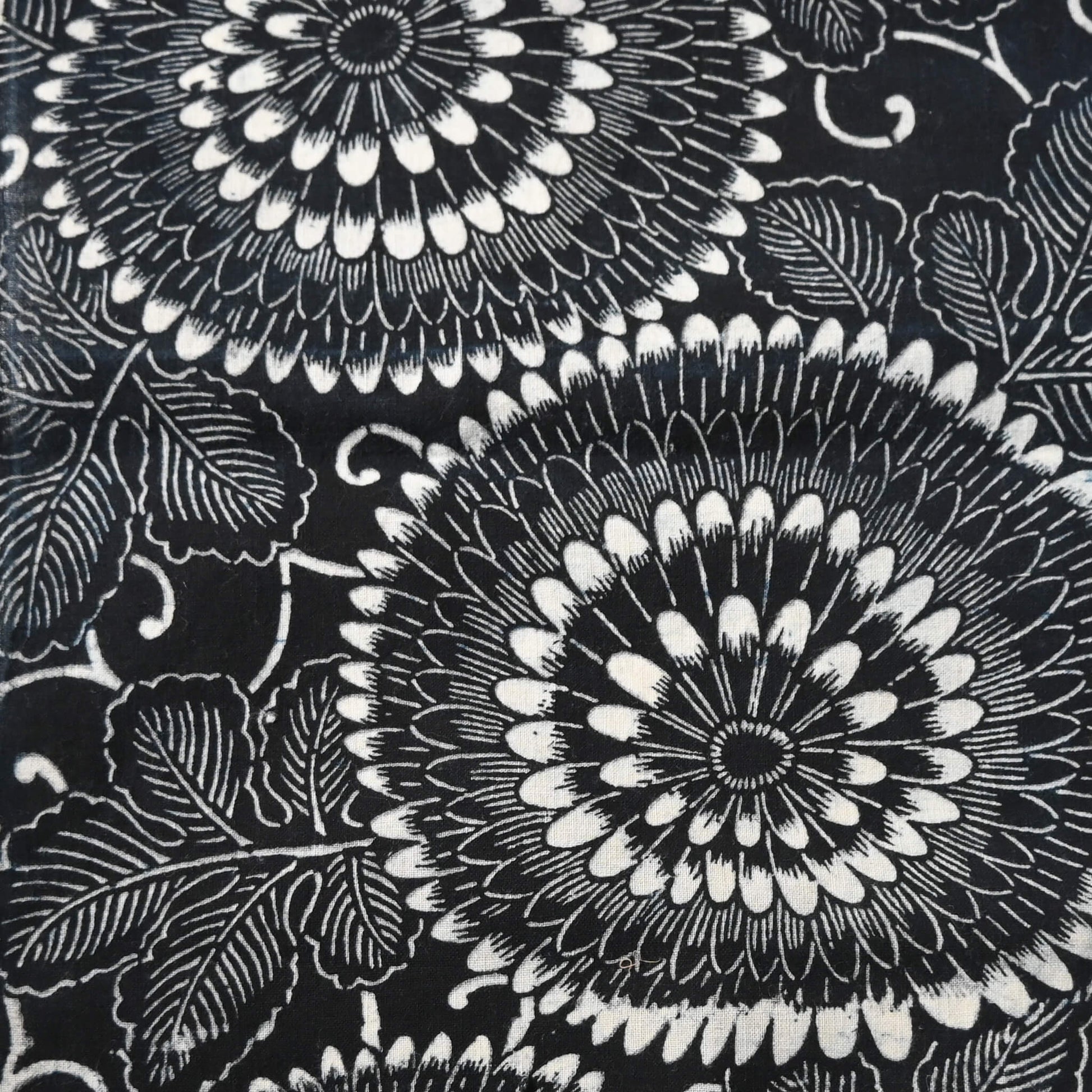 Close-up view of vintage indigo katazome stencil dyed cotton piece with a bold chrysanthemum design.