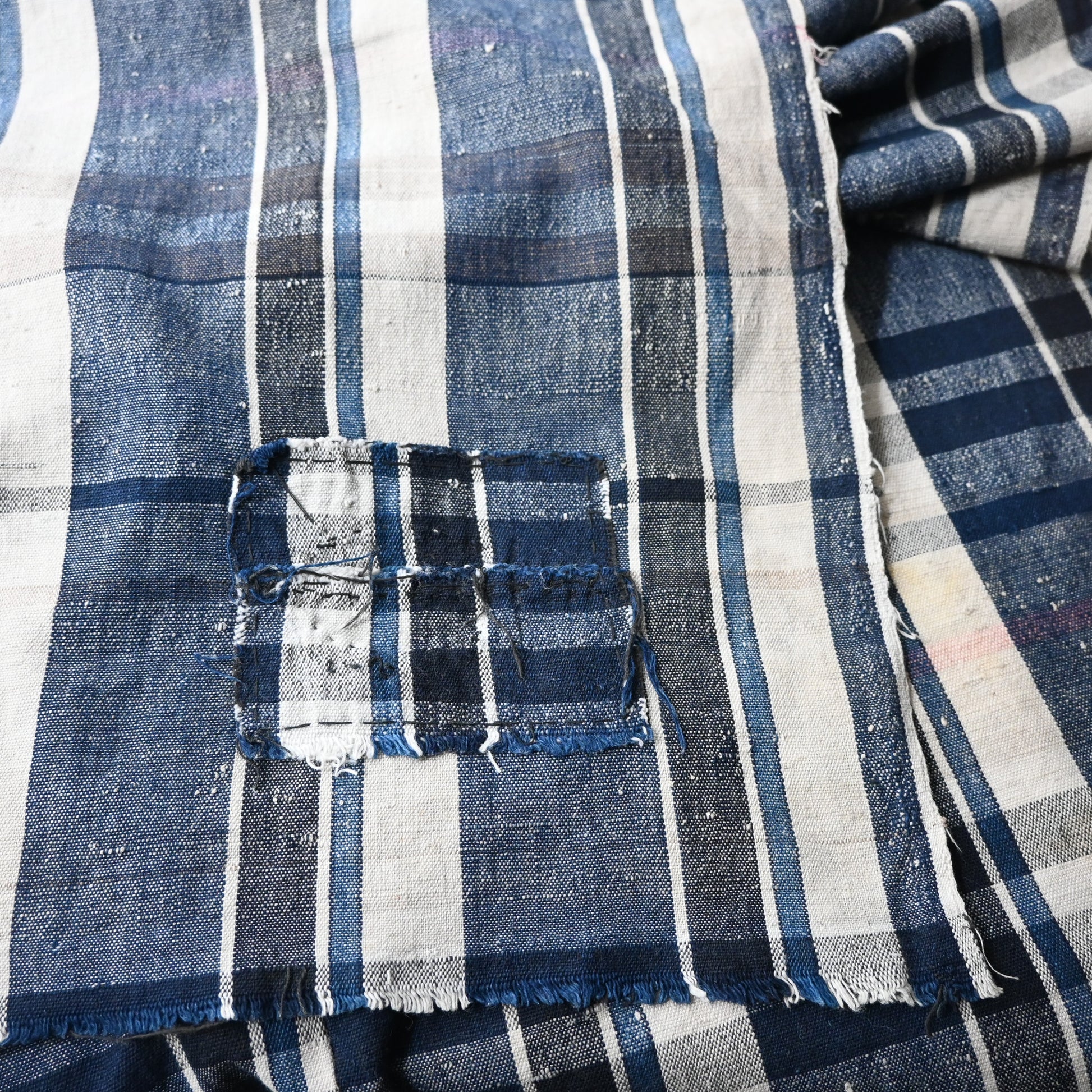 Close-up of vintage Japanese indigo plaid cotton futon cover with some small mended patches.