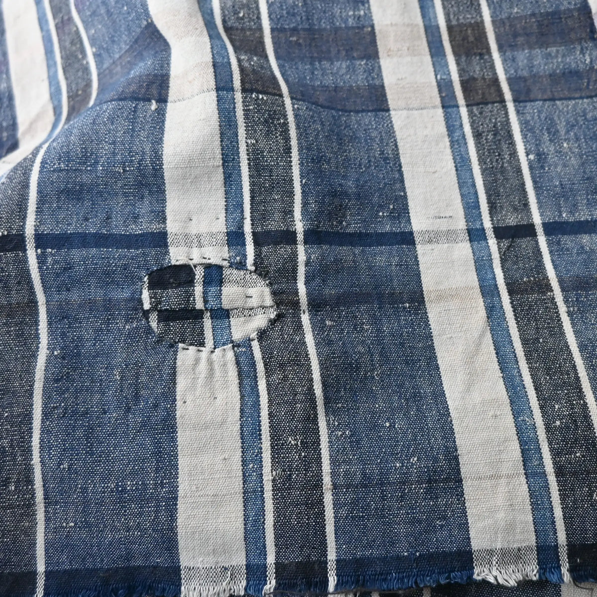 Close-up of vintage Japanese indigo plaid cotton futon cover with some small mended patches.