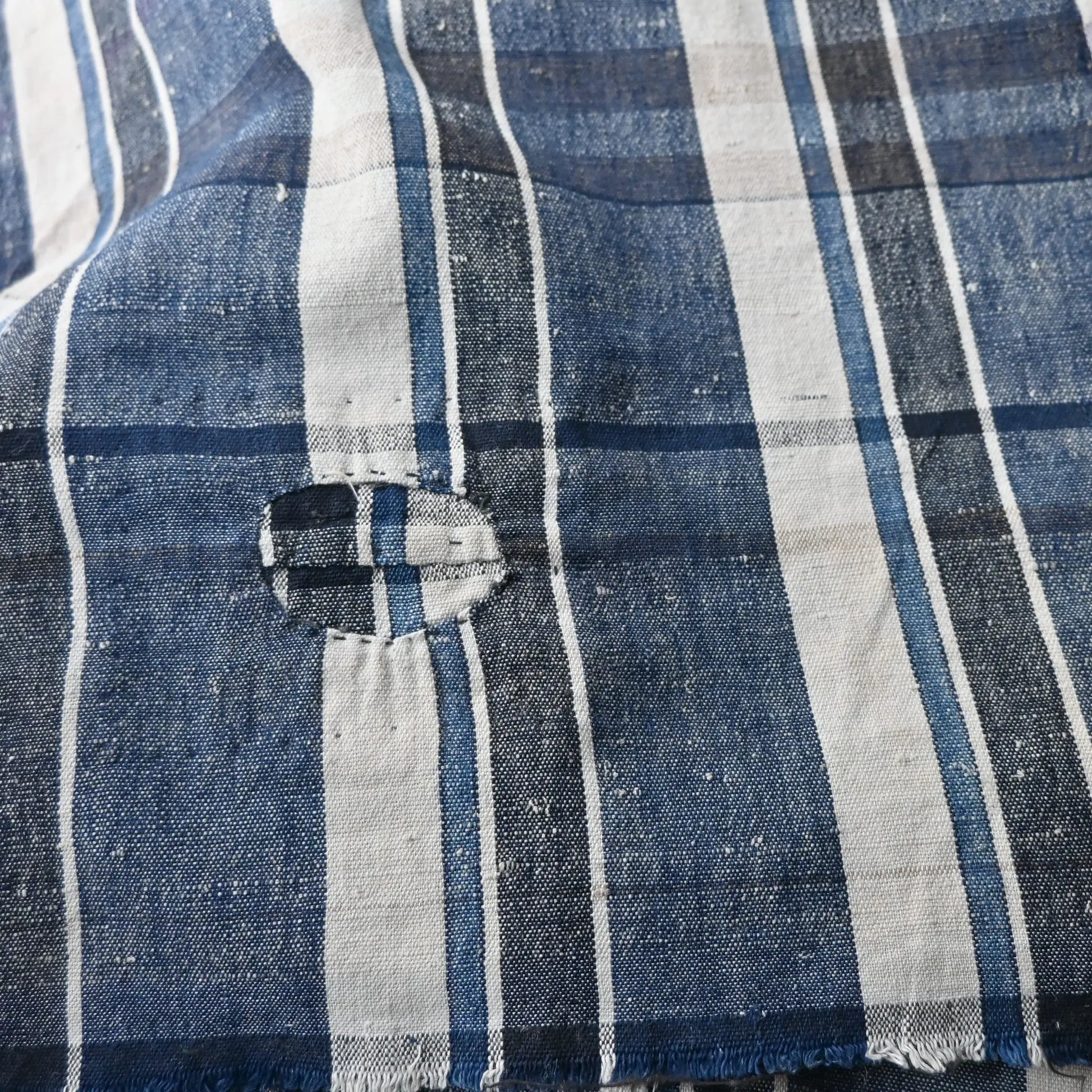 Close-up of vintage Japanese indigo plaid cotton futon cover with some small mended patches.