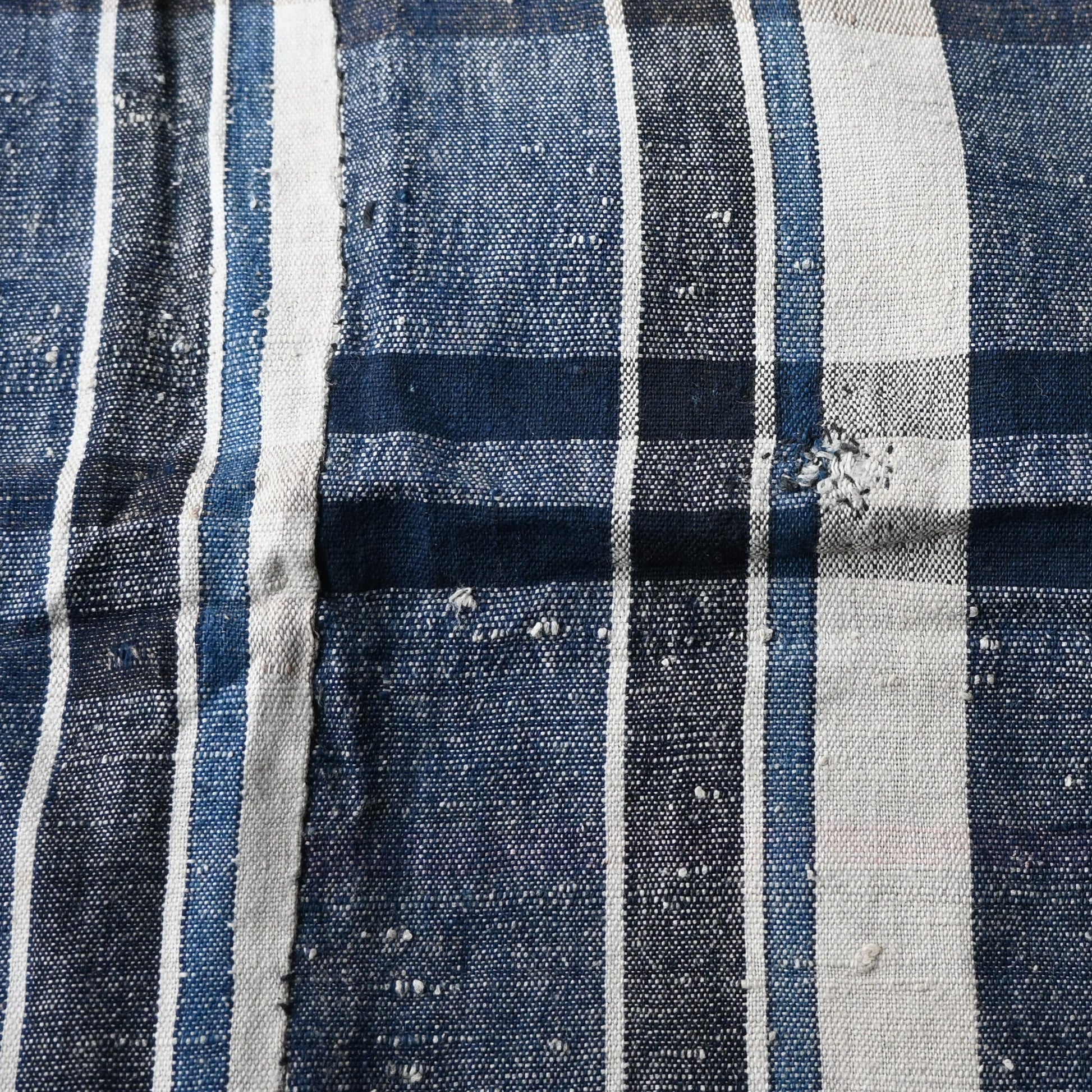 Close-up of vintage Japanese indigo plaid cotton futon cover with some small mended patches.