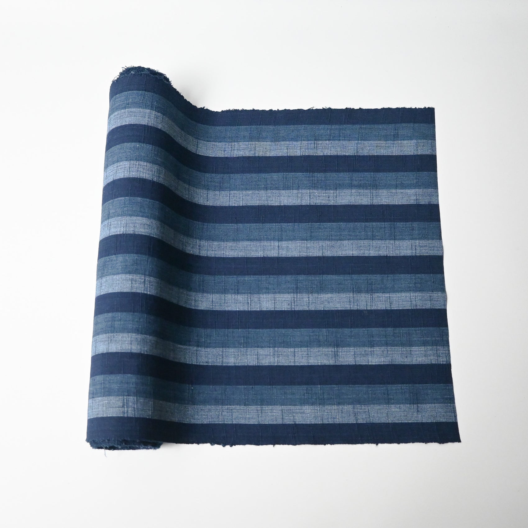 Vintage Japanese indigo tsumugi stripe cotton fabric roll.