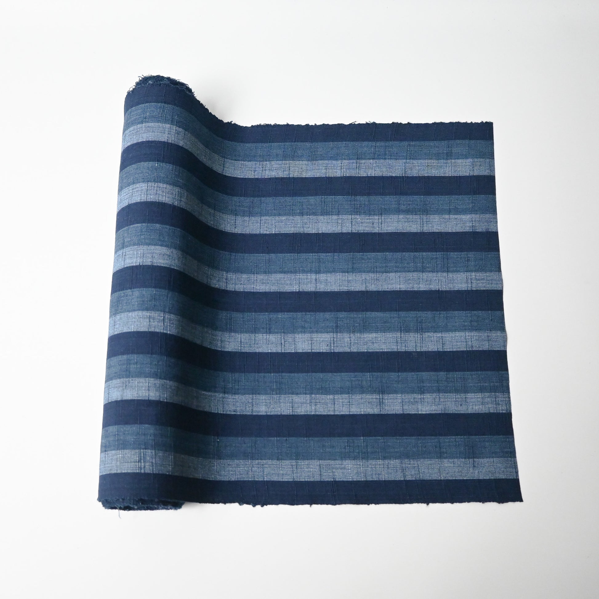 Vintage Japanese indigo tsumugi stripe cotton fabric roll.