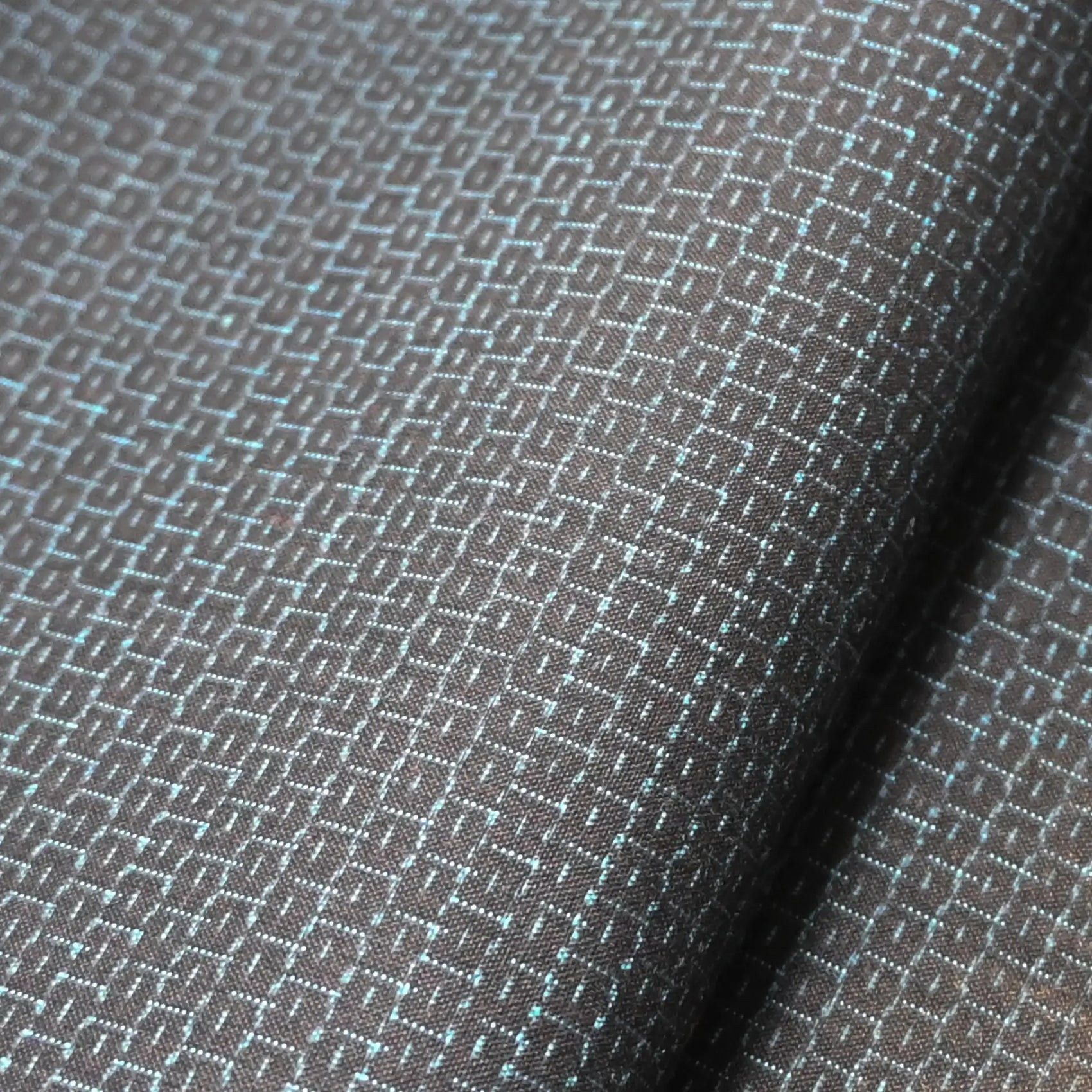 Close-up of vintage men's kimono silk fabric roll in black with blue woven Kikko hexagon motif.