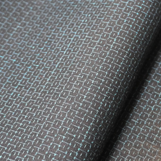Close-up of vintage men's kimono silk fabric roll in black with blue woven Kikko hexagon motif.